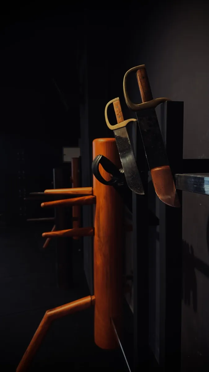 Wing Tsjun wooden dummy flanked by traditional butterfly swords